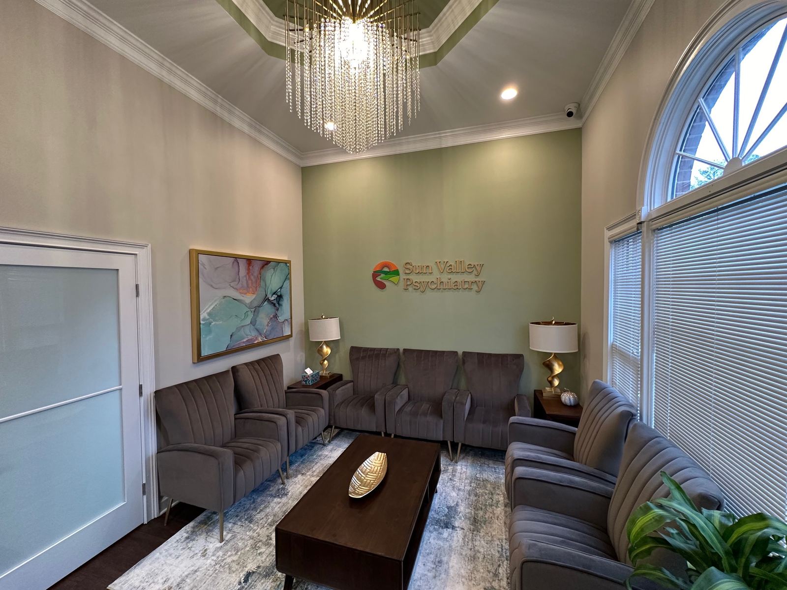 Waiting room at Sun Valley Psychiatry, with the chandelier and wall logo, offices in Roswell (Atlanta) and Dalton, Georgia
